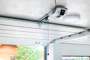 A new garage door opener with a red emergency string hanging down.