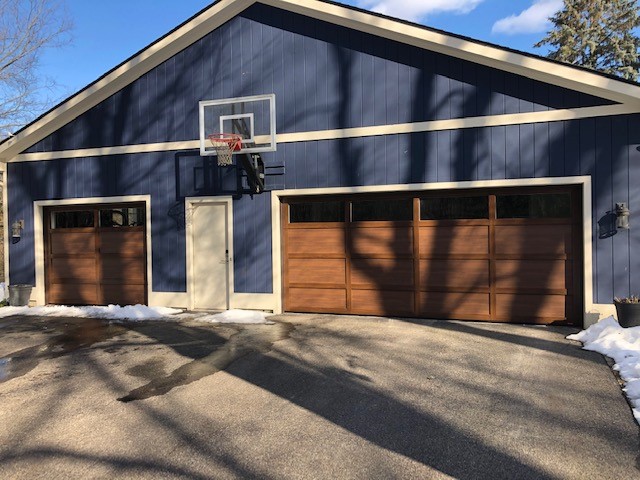 Environmental Door is your local garage door installer that installed these brown doors on this blue shed.