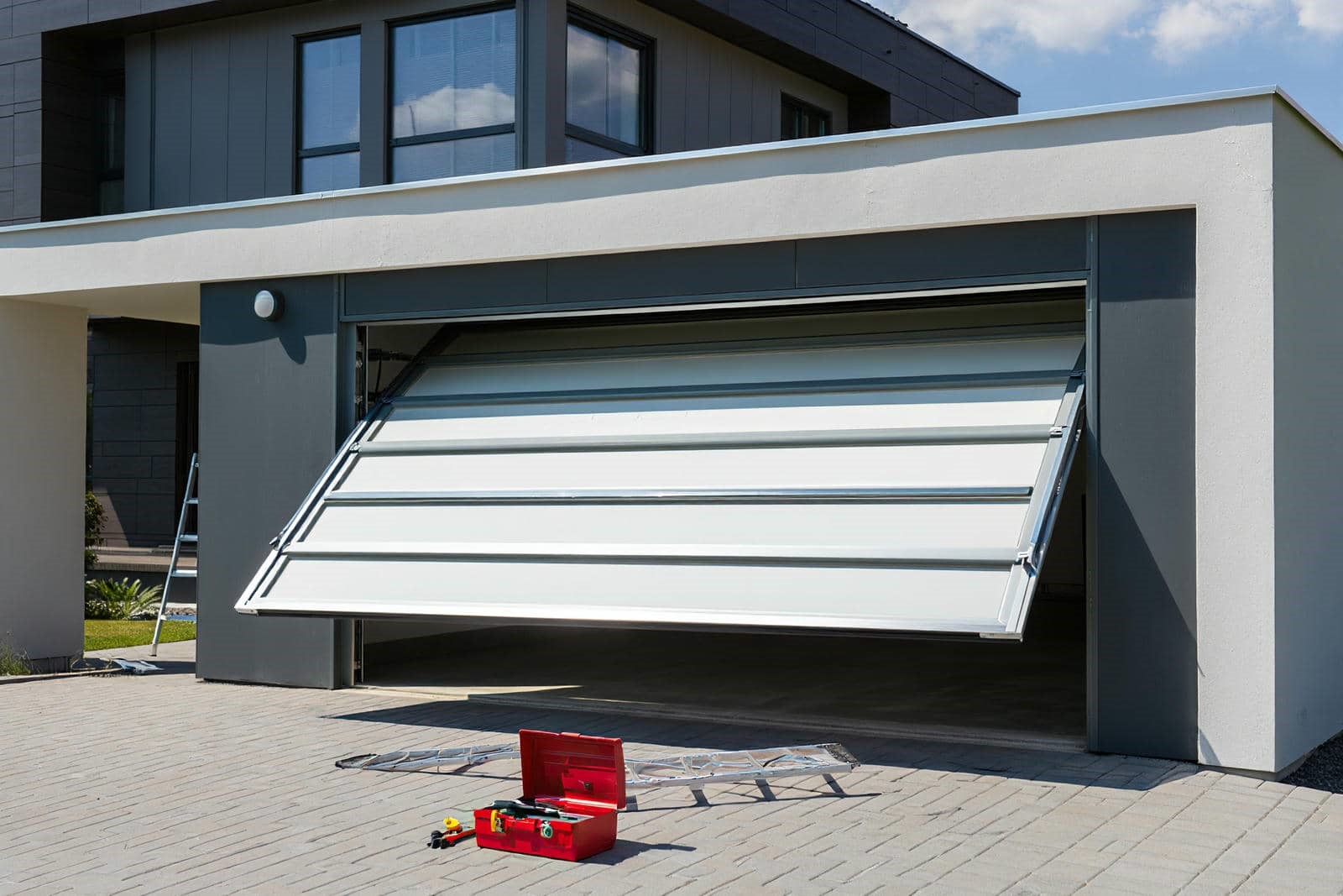 Garage door partially open with tools.