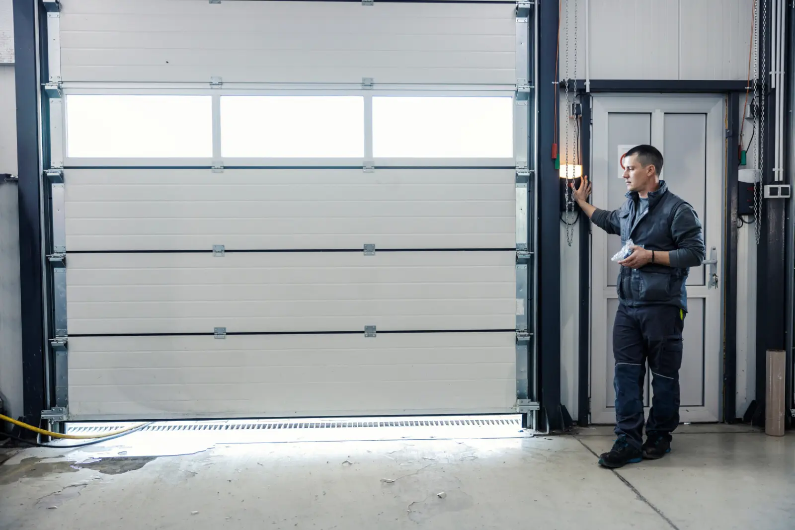 Auto mechanic opening Energy-Efficient Garage Door at the mechanic's workshop