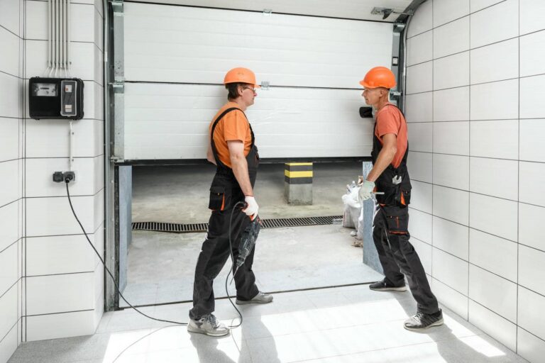 Two workers inspecting a garage door.