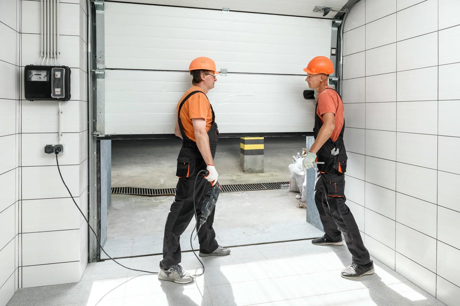 Two workers inspecting a garage door.