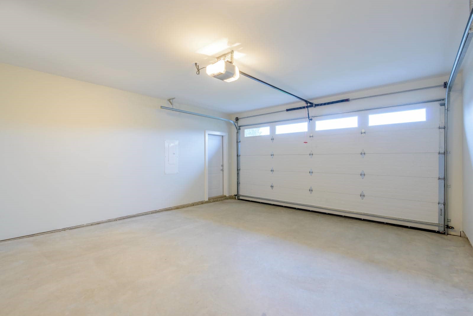 Empty garage with white door and lighting