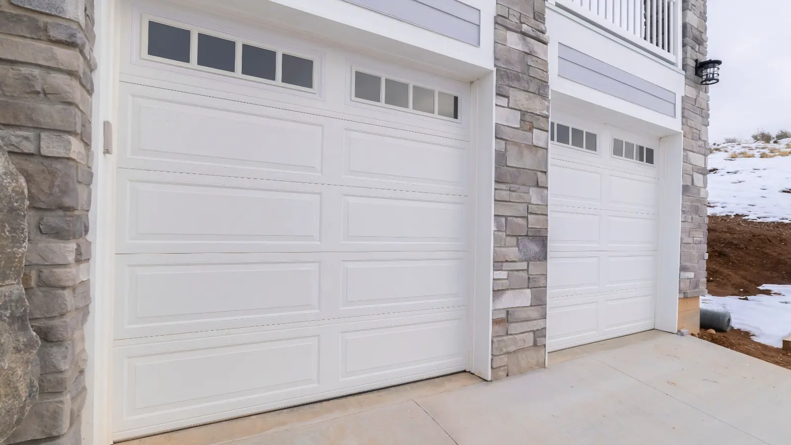 Garage Door Repair . Panorama White garage doors overlooking winter snow day light