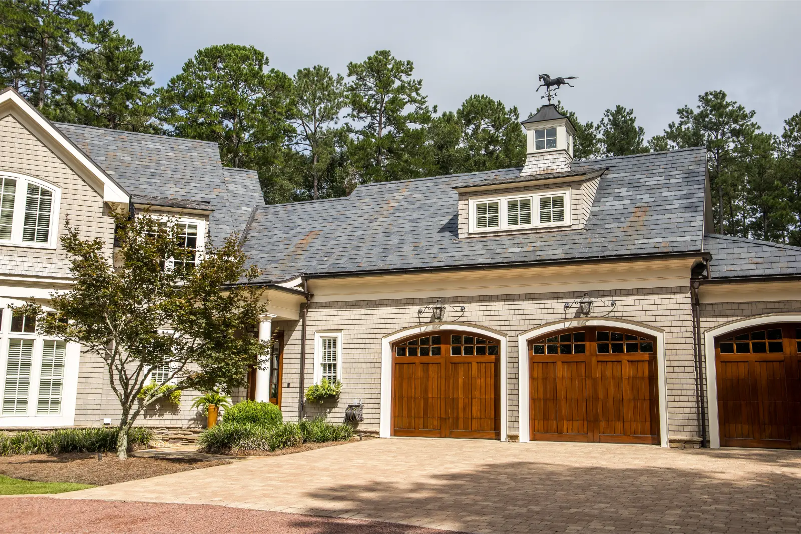 Affordable Garage Door Accessories: Stained wood triple custom garage doors for large southern home with curb appeal.