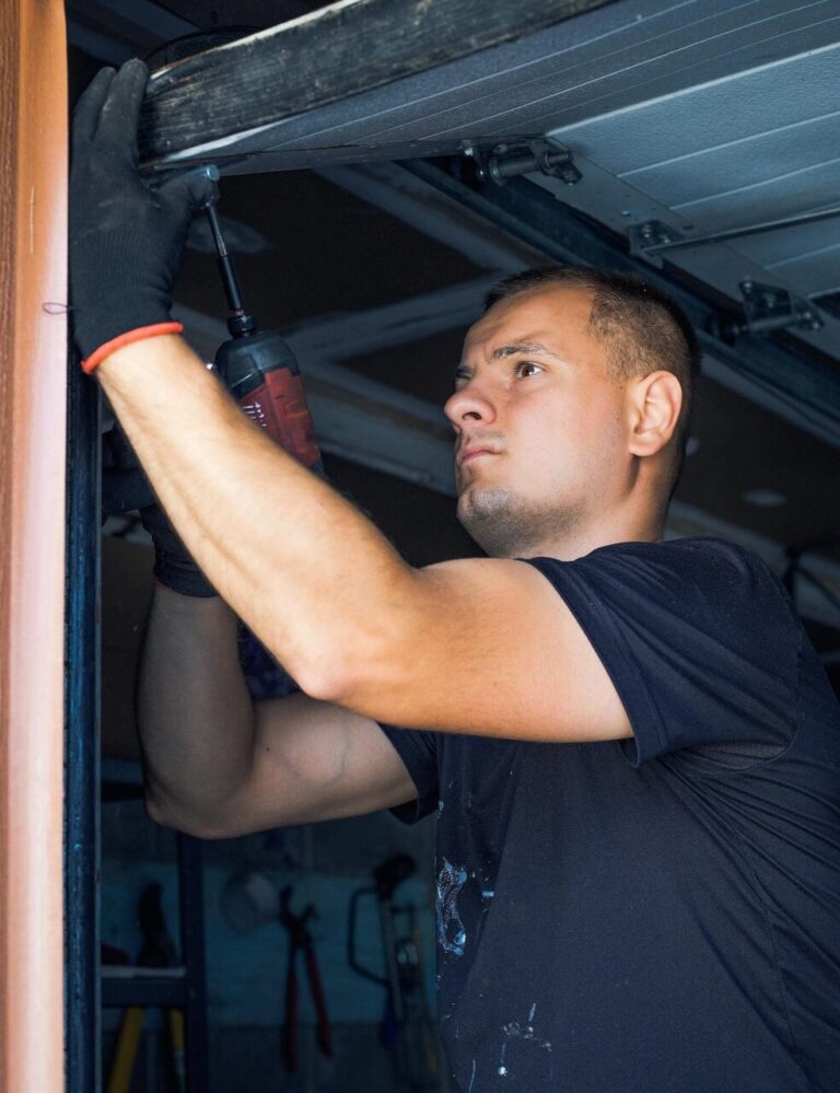 Person repairing a garage door mechanism.
