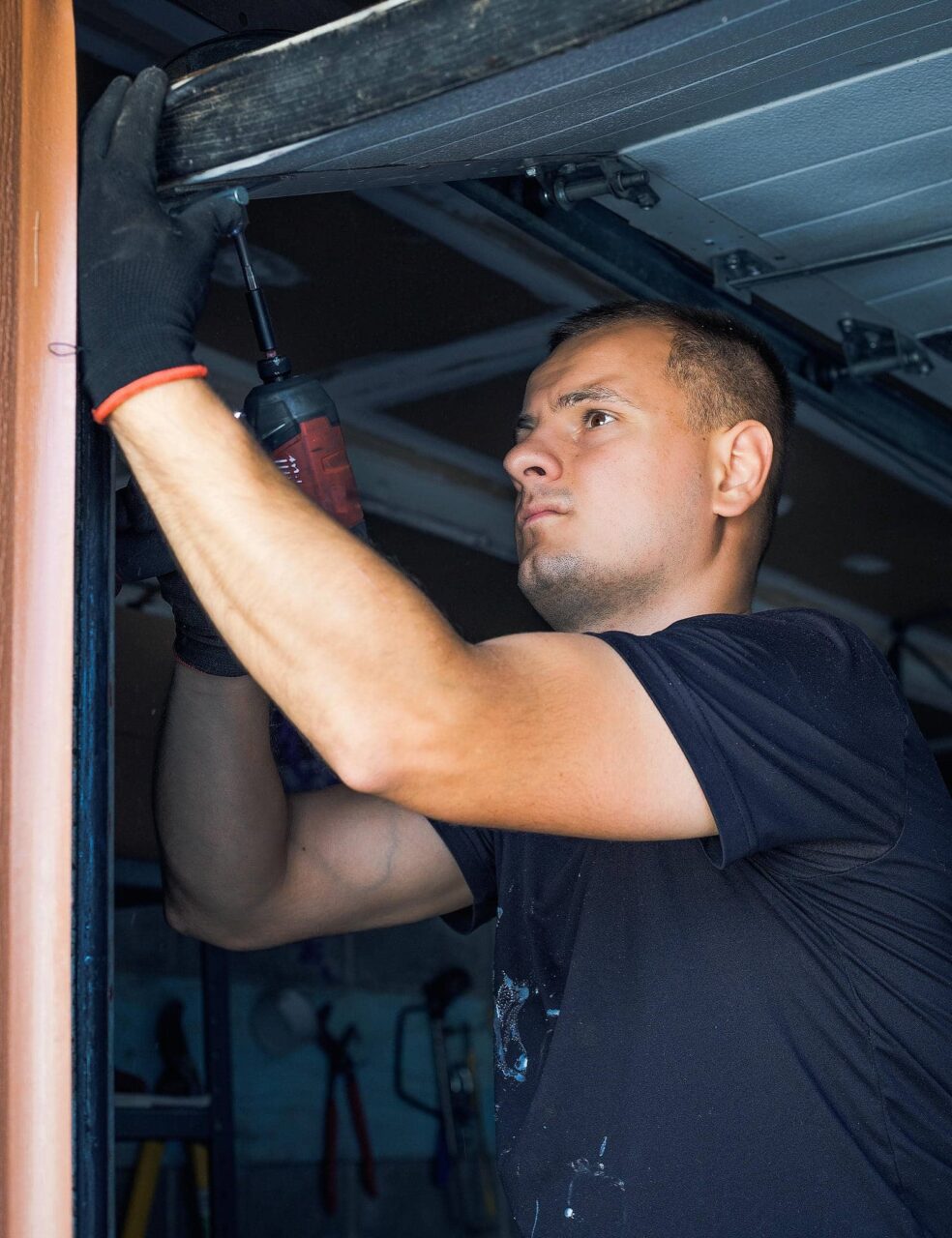Person repairing a garage door mechanism.