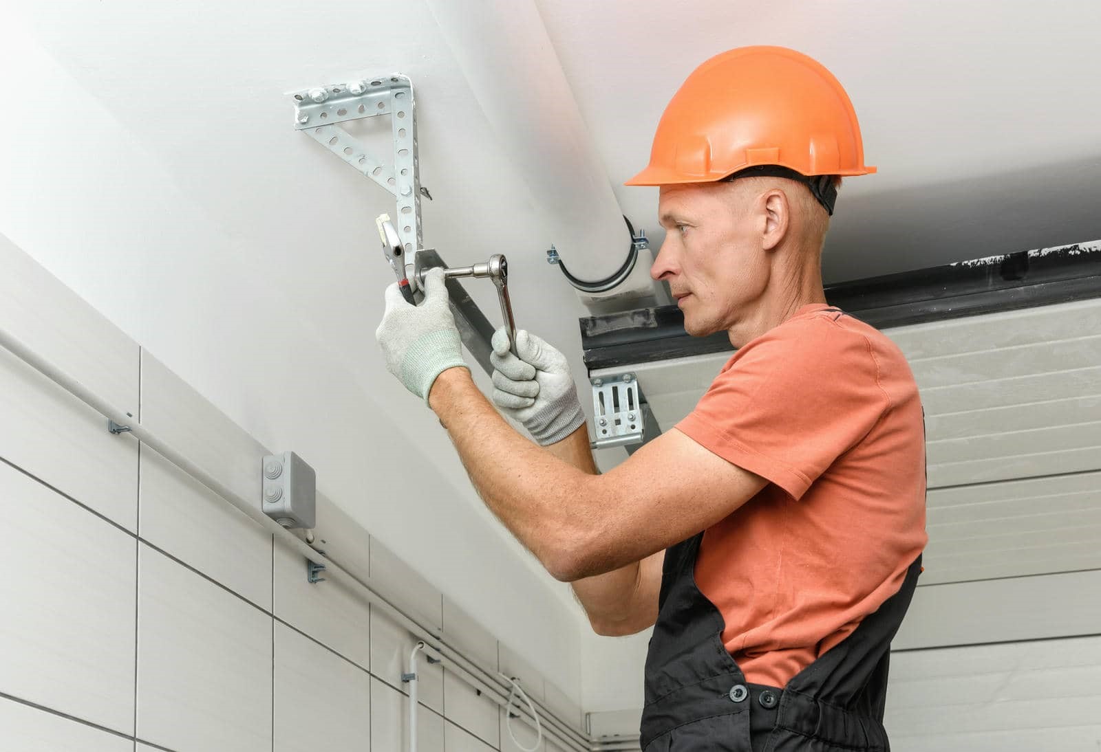 Person repairing garage door mechanism.