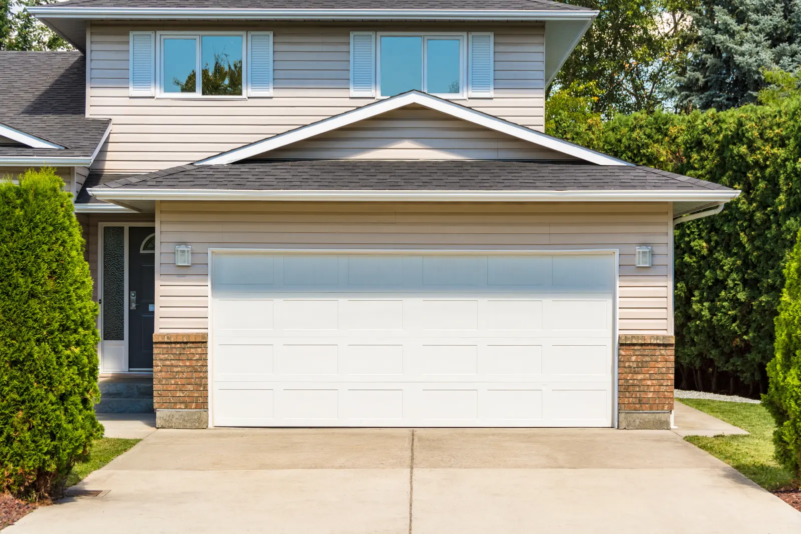 Garage Door Installation Guide and a Wide garage door of residential house with concrete driveway in front