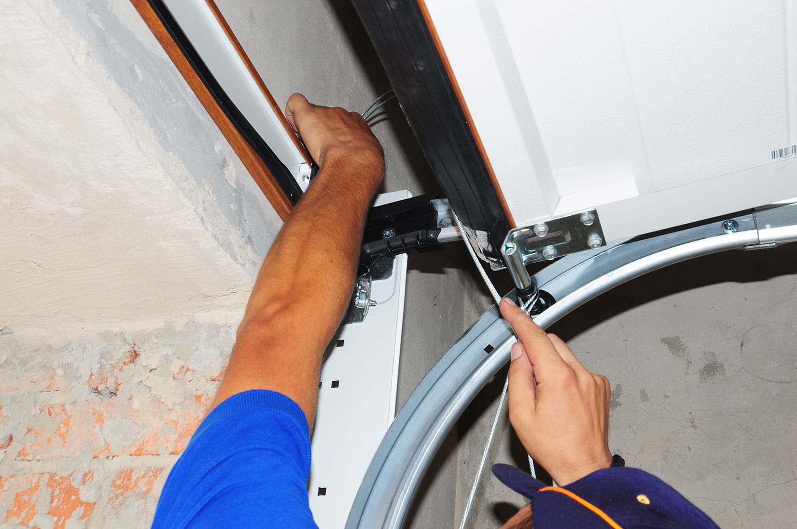 What happens when the garage door is noisy? You fix it! An Environmental Door technician repairs a loose garage door panel.