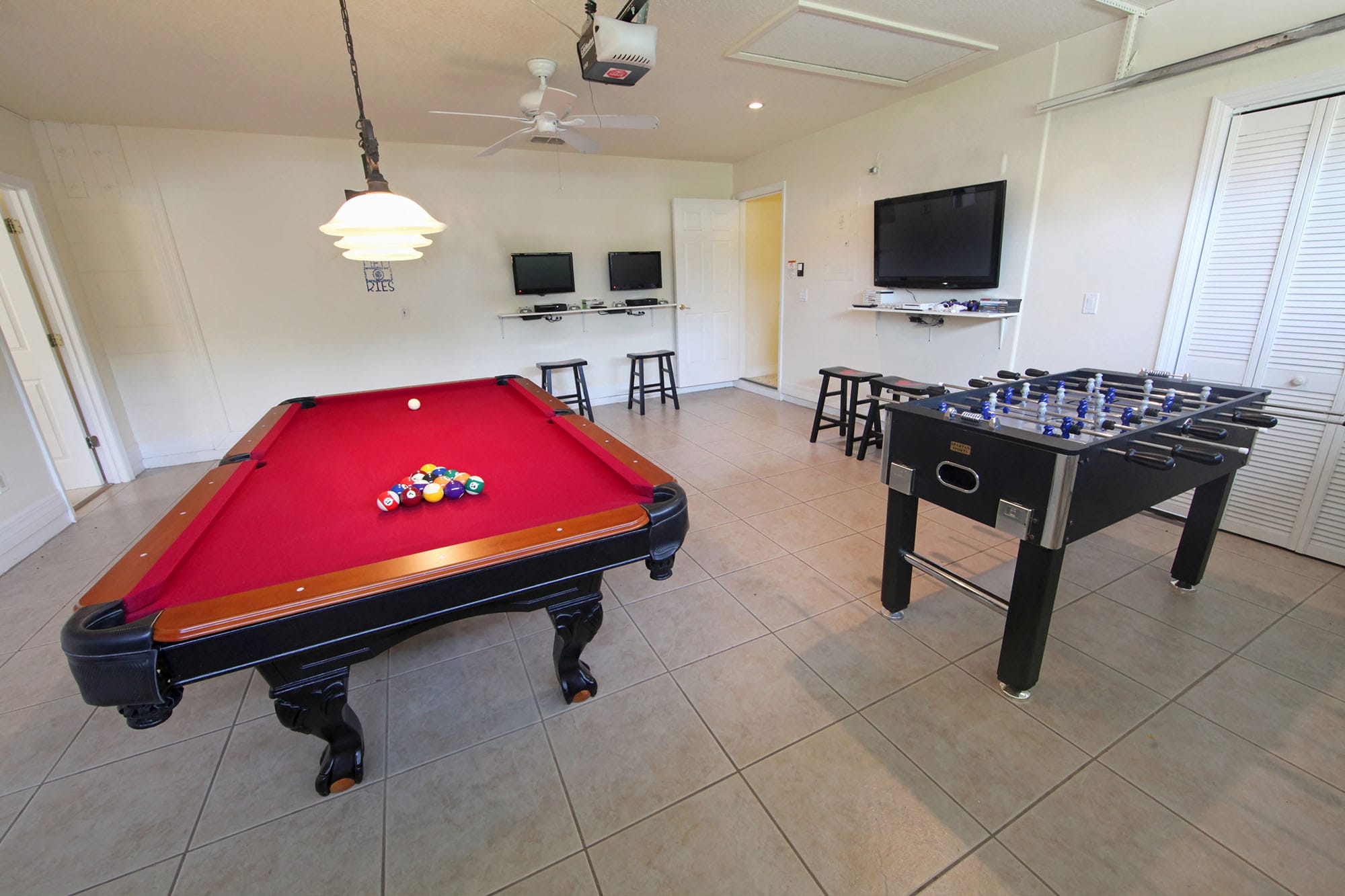 Converting a garage into an enteratinment space is nothing new, but you still have need protection. A pool table and foosball table in a converted garage.